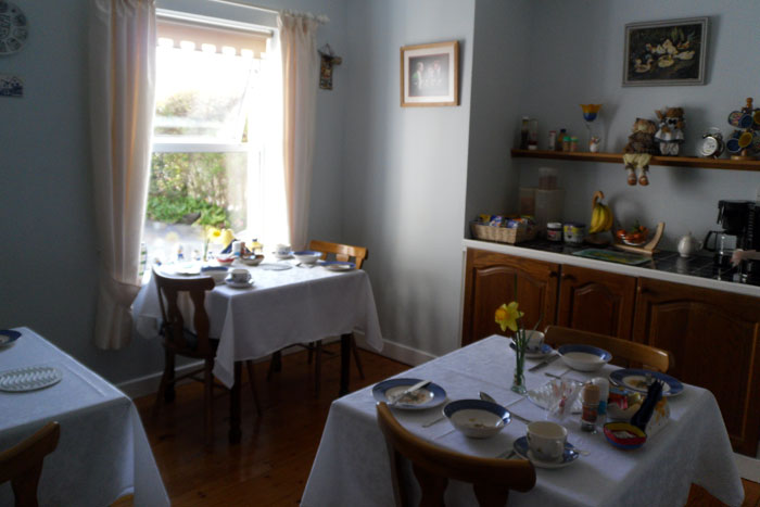 The breakfast room at Avondale B&B, with tables set in white linen and blue-and-white china.